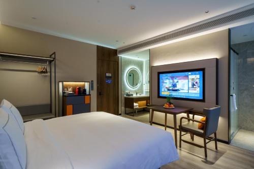 深圳深圳福田CBD逸扉酒店的一间卧室配有一张大床和电视