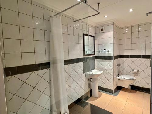 温特和克Hotel Thuringerhof的带淋浴、盥洗盆和卫生间的浴室