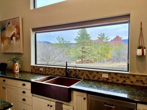 塞多纳Sedona Uptown Gem! Wow! Views!! NEW! BARREL SAUNA!!! Close to trails, walk to Uptown Sedona, restaurants and shopping的一个带水槽和大窗户的厨房