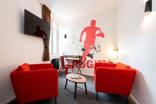 比亚里茨Urban Style Biarritz Le Relais的客厅配有两把红色椅子和一幅画画