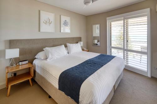 珀斯海贝士嘉堡酒店的一间卧室设有一张大床和一个窗户。
