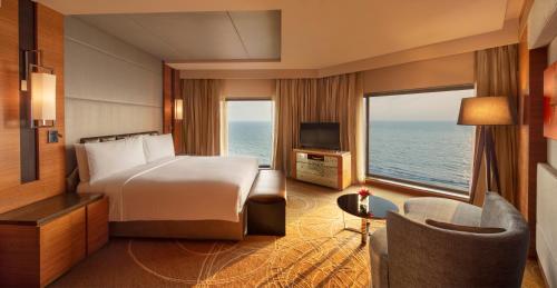 孟买JW珠瑚孟买万豪酒店的一间卧室配有一张床,享有海景