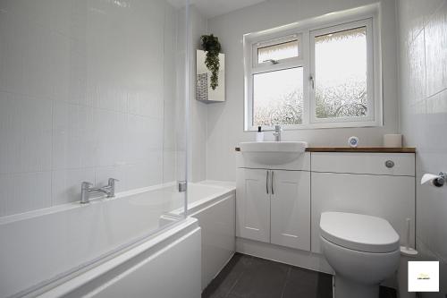 弗里姆利Camberley Spacious and Comfy 3 Bedroom Home, Next to Frimley Hospital with Parking的白色的浴室设有卫生间和水槽。