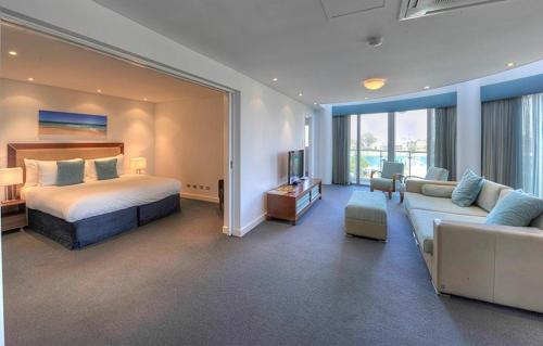 曼哲拉贝壳曼德拉酒店的一间卧室配有一张床,客厅配有沙发