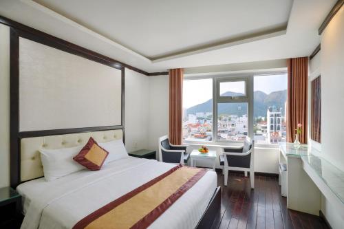 芽庄Minh Tuyết Luxury Hotel managed by HT的酒店客房设有一张床、一张书桌和窗户。