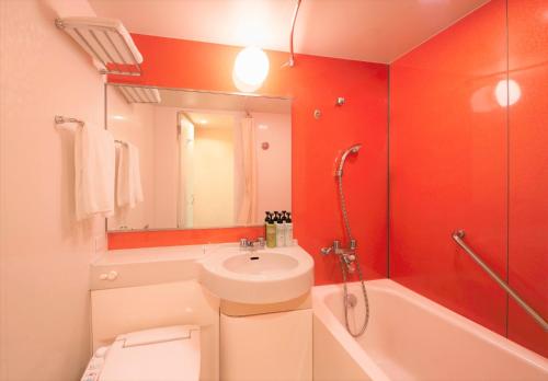 千叶千叶滨野R16岐山酒店的浴室配有盥洗盆、卫生间和浴缸。
