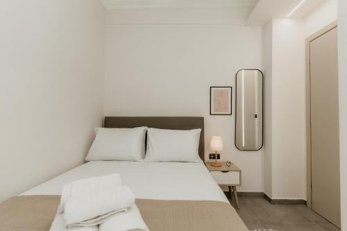 塞萨洛尼基Urban Elegance in Thessaloniki的白色卧室配有床和镜子