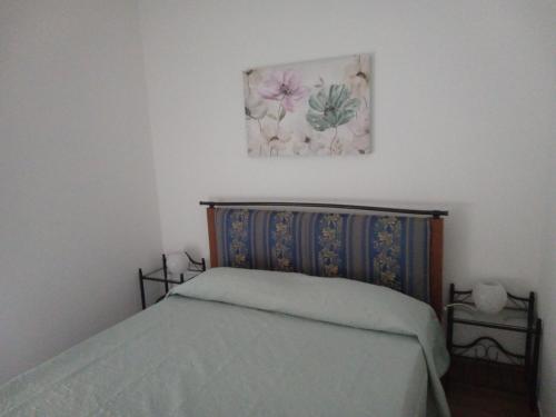 圣焦万尼泰亚蒂诺Dolce Casa的卧室配有一张床,墙上挂着一幅画