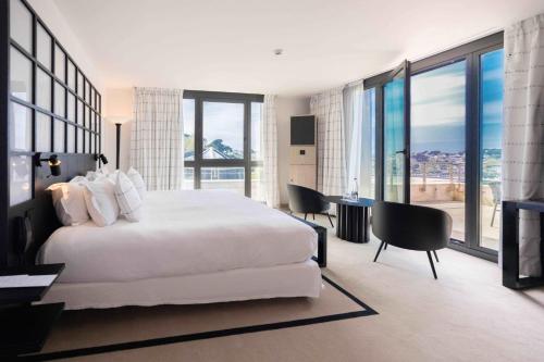 佩罗斯-吉雷克L'Agapa Hôtel - Spa Codage的卧室配有白色的床和桌椅