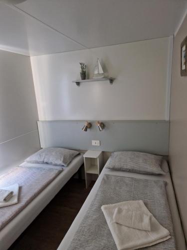 比奥格勒·纳·莫鲁Mobile Homes 'JAKOV', Camp Soline的小型客房配有两张床铺、桌子和书架。