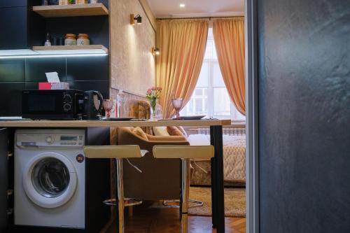 敖德萨Central Apartments的厨房配有桌子和洗衣机。