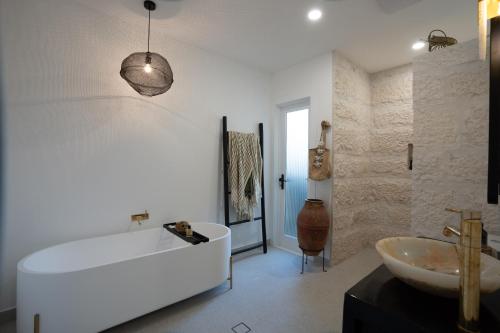 悉尼The Manly House - 100 steps from Manly Beach的白色的浴室设有浴缸和水槽。