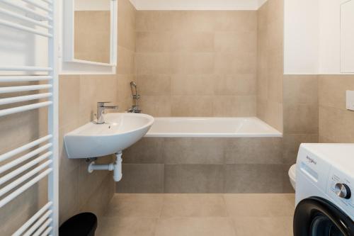 PrievozUrban & Green Apartments by Ambiente的浴室配有盥洗盆和浴缸。
