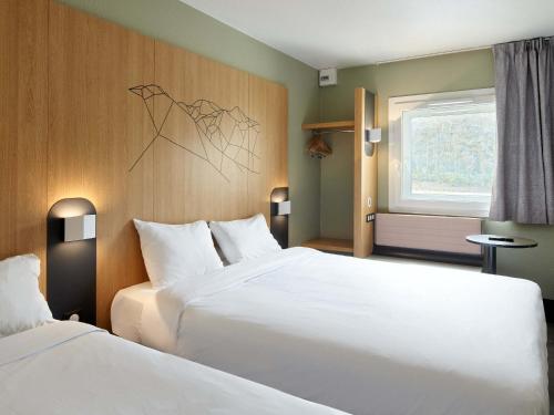 鲁瓦西昂法兰西B&B HOTEL Paris Roissy CDG Aéroport的酒店客房设有两张床和窗户。