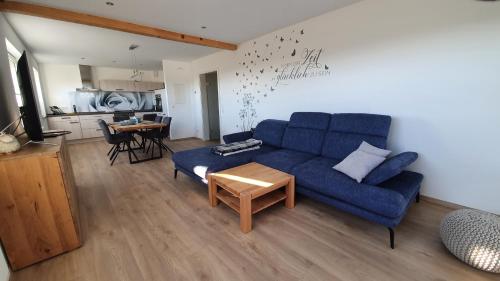 马瑟尔贝格Schnetter Hummel, Apartment 1的客厅配有蓝色的沙发和桌子