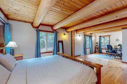 ChristinaLakeview Chalet的一间带一张大床的卧室,位于一个拥有木制天花板的房间