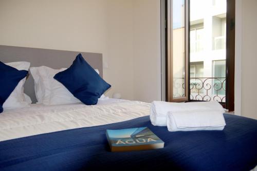 埃斯平霍Cabo do Mar Apart- Azul Beach的一间卧室配有一张床,上面有一本书
