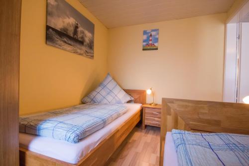 比苏姆Haus-Karin-Ferienwohnung-2的一间小卧室,配有两张床和床头柜