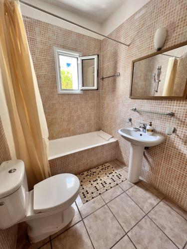 帕福斯Pafia Sunbeach Townhouse的浴室配有卫生间、盥洗盆和浴缸。