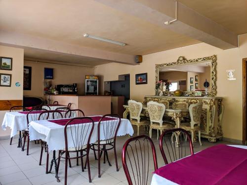 布拉索夫武士之家膳食公寓的一间带桌椅和镜子的用餐室