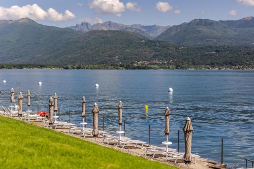 巴韦诺Lago Maggiore Bay的湖畔的一排椅子和遮阳伞