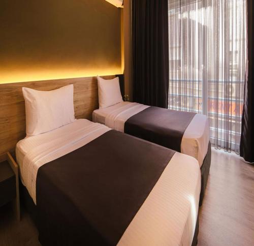 切什梅Grand Faik Hotel的酒店客房设有两张床和窗户。
