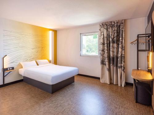 布吕兹B&B HOTEL Rennes Parc Expo Aéroport的酒店客房设有床和窗户。