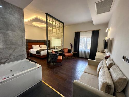 MidyatMidyat Royal Hotel & Spa的酒店客房设有沙发、床和浴缸。