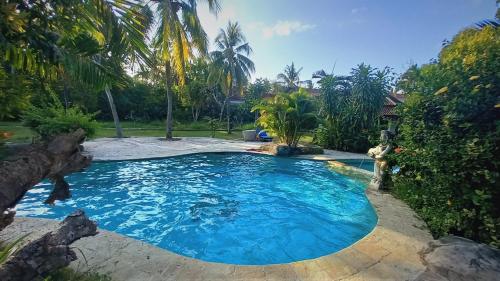 龙目岛库塔Matahari Inn Kuta Lombok的棕榈树庭院内的游泳池
