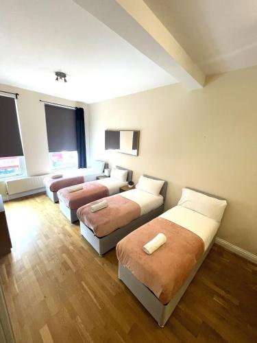 伦敦Camden Budget Suites - Next to Station and Camden Market的酒店客房,设有三张床和一张沙发