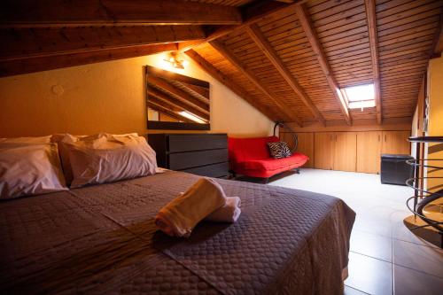 耶拉基尼Delmare Olive beach house I的一间卧室配有一张床和一张红色椅子