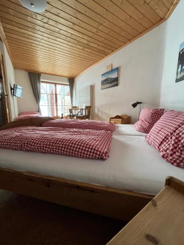 Landhaus Alpenstern的一张配有红白毯子和枕头的大床