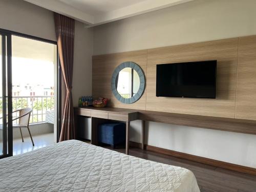 海阳Khách Sạn Sông Lô的一间卧室配有电视和一张书桌及一张床