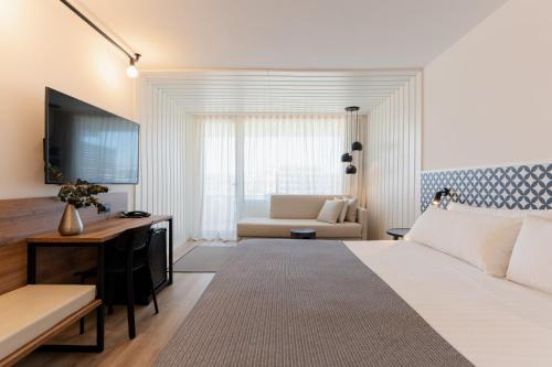 萨洛白玉兰酒店 - 仅限成人的一间卧室配有一张床、一张桌子和一张沙发