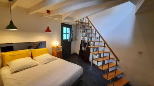 CrosGîte avec piscine et jacuzzi partagés en Cévennes的一间卧室设有一张床和一个螺旋楼梯