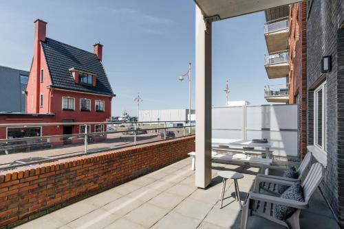 斯海弗宁恩BizStay Harbour IV的阳台设有长凳,享有建筑的景致。
