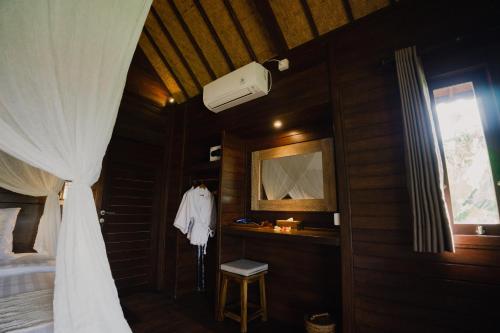 蓝梦岛Sunset Star Huts的卧室配有一张带白色窗帘的床和窗户。