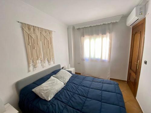 兰哈龙Ático Lanjarón的一间卧室设有蓝色的床和窗户。