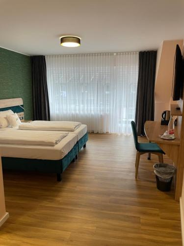 海姆巴赫Art Hotel Eifel的一间卧室配有一张床、一张桌子和一把椅子