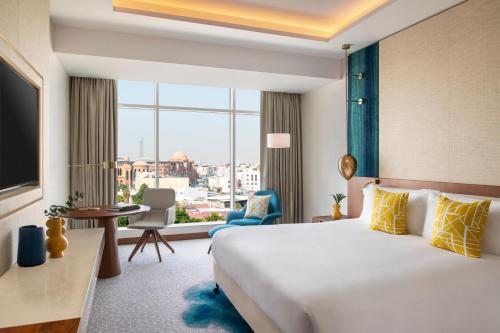 多哈Abesq Doha Hotel and Residences的酒店客房设有一张床和一个大窗户