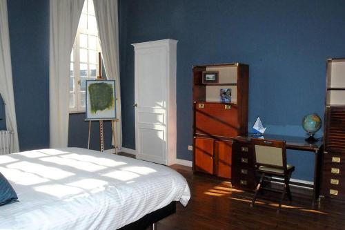 BeloeilPetit château à la campagne.的一间卧室配有一张床、一张书桌和一个窗户。