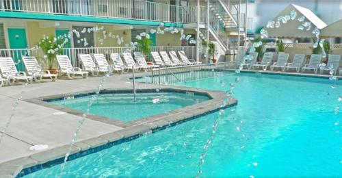 威尔伍德克拉斯特水族海滩酒店 的酒店设有一个大型游泳池,配有椅子