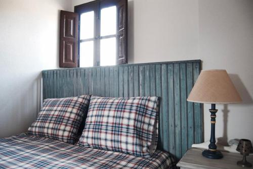 Garganta de los MontesLA MINA Alojamiento en plena naturaleza的一张带枕头的床和一张桌子上的台灯