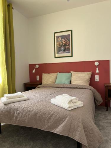 里摩日THEIA Hotel & Suites - Limoges Centre的一间卧室配有一张床,上面有两条毛巾