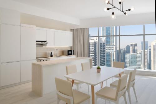 多哈Element by Westin West Bay Doha的厨房以及带白色桌椅的用餐室。