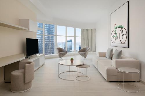 多哈Element by Westin West Bay Doha的客厅配有沙发、椅子和电视