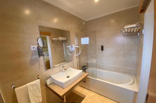 纳扎雷马尔酒店的浴室配有盥洗盆和浴缸。