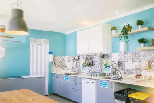 里斯本都市花园旅馆 的厨房设有蓝色的墙壁和白色的橱柜。