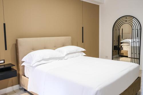 那不勒斯Aroma Apartment, Maschio Angioino-Porto Di Napoli的卧室配有白色的床和镜子