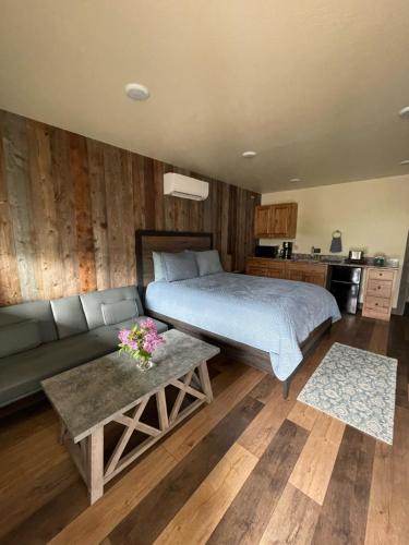 加德纳Rhodopa Lodge at Yellowstone的一间卧室配有一张床、一张沙发和一张桌子